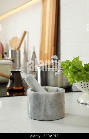 Mortier de marbre avec pilon sur le comptoir de cuisine. Ustensiles de cuisine Banque D'Images