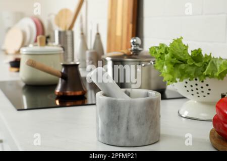 Mortier de marbre avec pilon sur le comptoir de cuisine. Ustensiles de cuisine Banque D'Images