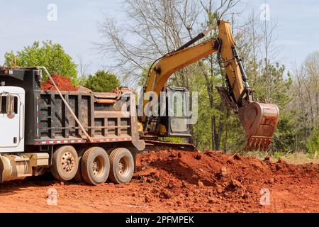 Chargement de la terre dans un camion-benne sur le chantier avec une pelle hydraulique Banque D'Images