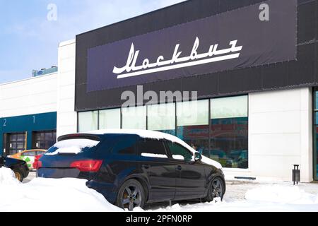 SAINT-PÉTERSBOURG, RUSSIE - 13 MARS 2023 : une pancarte portant le nom de la marque russe 'Moskvich' sur le bâtiment de la concession automobile sur une neige de mars Banque D'Images