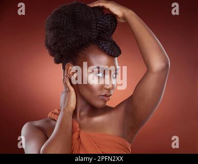 Sa beauté parle d'elle-même. une jeune femme attrayante posant en studio sur un fond rouge. Banque D'Images