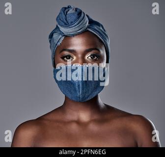Le port d'un masque ne vous permettra pas de vous éloigner de votre beauté, il s'ajoute à lui. une belle jeune femme portant un masque et un serre-tête en denim. Banque D'Images