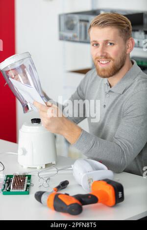 réparateur examinant l'appareil dans la cuisine Banque D'Images