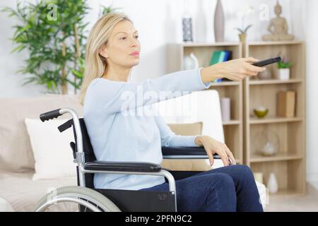 portrait d'une femme âgée handicapée regardant la télévision Banque D'Images