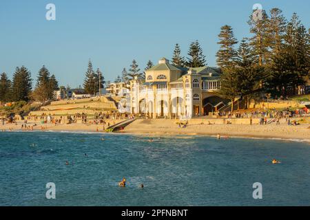 Les personnes se détendant et se baignant en fin d'après-midi devant le pavillon emblématique de la plage de Cottesloe à Perth, Banque D'Images