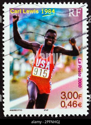FRANCE - VERS 2000 : un timbre imprimé en France montre Carl Lewis (médaillé d'or olympique 100m, 200m, 100m relais et saut long, 1984), vers 2000. Banque D'Images