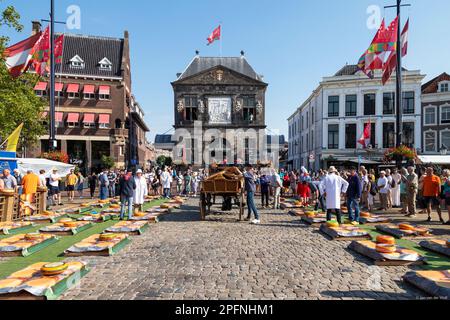 Marché aux fromages sur la place centrale du marché avec vue sur la maison de pesée Goudse Waag, construite en 1668. Banque D'Images