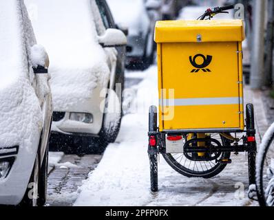 Schwerin, Allemagne. 10th mars 2023. Un vélo de transport de lettres est stationné sur le trottoir de la vieille ville en forte chute de neige. Sur 10 mars 2023, commence le quatrième cycle de négociations dans le conflit de négociation collective à Deutsche Post. Il s'agit d'une nouvelle convention collective pour environ 160 000 salariés de la division Post & Parcel Allemagne. Verdi exige 15 pour cent de plus d'argent. Credit: Jens Büttner/dpa/Alay Live News Banque D'Images