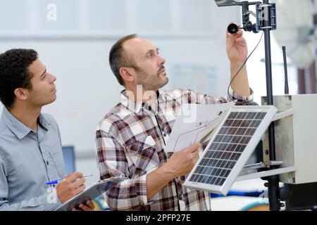 les électriciens mesurent les panneaux solaires avant l'installation Banque D'Images