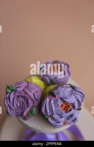 Sur fond rond en bois se trouvent les guimauves naturelles sous forme de fleurs de pivoine pourpres. Desserts sucrés sans sucre. Pâtisseries créatives. Banque D'Images
