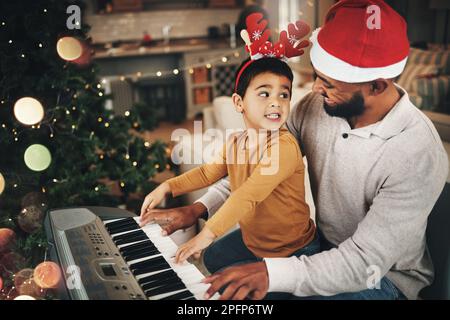 Joyeux famille, père et enfant au piano pour les fêtes de noël, les chants et les Noël à la maison. Parent, garçon enfant et instrument de clavier d'enseignement, festif Banque D'Images