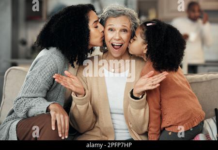 Portrait, surprise ou amour avec une fille et une petite-fille embrassant une femme âgée sur la joue dans une maison. Fête des mères, wow ou enfants avec une fille Banque D'Images