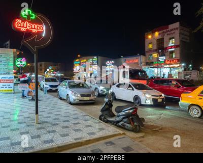 Bagdad, Irak - 20 février 2023 : vue de nuit sur la rue Al-Maghreb, connue pour ses nombreuses cliniques médicales et pharmacies. Banque D'Images