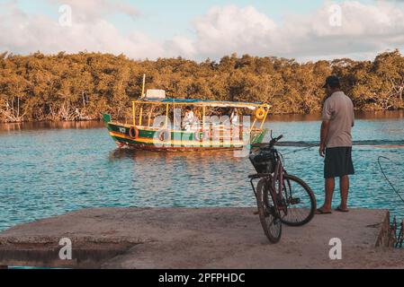 Valentica, Bahia, Brésil - 09 septembre 2022 : bateau naviguant sur la rivière una en fin d'après-midi tout en pêchant à la maison sur la rive. Ville de Valenca, Banque D'Images