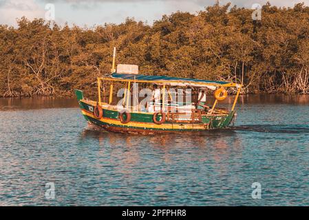 Valentica, Bahia, Brésil - 09 septembre 2022 : bateau naviguant sur la rivière una en fin d'après-midi tout en pêchant à la maison sur la rive. Ville de Valenca, Banque D'Images