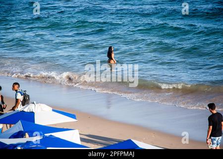 Salvador, Bahia, Brésil - 22 octobre 2022: Les gens les touristes marchant et se détendant à la plage de Farol da Barra en journée chaude. Salvador, Bahia. Banque D'Images