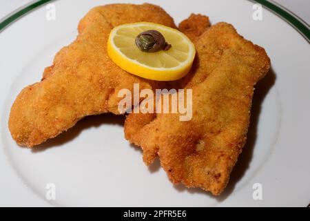 Wiener Schnitzel Cutlet pané de veau avec garniture viennoise ou Wiener Garnitur composé d'une roue de citron et d'un anneau d'anchois Banque D'Images