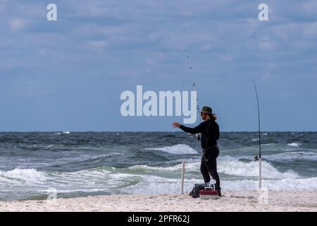 Un pêcheur se fait une idée de ses lignes sur la plage de Perdido Key en Floride sur 16 mars 2023. Banque D'Images