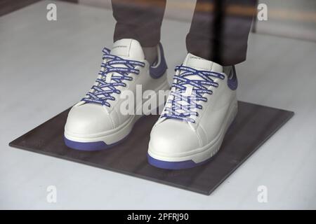 Baskets en cuir doux d'Armani avec lacets avec logo dans une fenêtre de magasin Banque D'Images