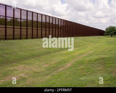 Debout et imposant, la clôture en acier rouillé sur la frontière USA-Mexique à Laredo, Texas sert de rappel visuel de la relation complexe être Banque D'Images