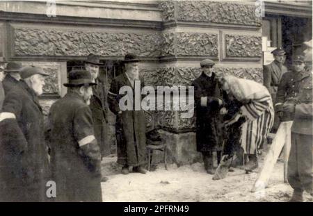 Dans les premiers stades de WW2, les Juifs dans l'europe occupée nazie ont été arrondis et forcés dans des ghettos surpeuplés. Quand la décision a été prise des tuer tous ils ont été déportés vers des centres d'extermination pour être assassinés. . Cette image déchire les officiers SS obligeant les Juifs à prier dans la rue en présence de policiers juifs (Lwow) Lviv. Banque D'Images