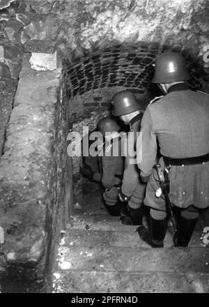 Dans les premiers stades de WW2, les Juifs dans l'europe occupée nazie ont été arrondis et forcés dans des ghettos surpeuplés. Quand la décision a été prise des tuer tous ils ont été déportés vers des centres d'extermination pour être assassinés. Cette image montre les soldats allemands descendant dans les sous-sols profonds de la ville de Lublin à la recherche de juifs cachés. Banque D'Images