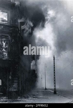 En janvier 1943, les nazis sont arrivés pour arrondir les Juifs du ghetto de Varsovie les Juifs, résolus au combattre, ont pris la SS avec des armes maison et primitives. Les défenseurs ont été exécutés ou déportés et la zone du ghetto a été systématiquement démolie. Cet événement est connu sous le nom de soulèvement du ghetto. Cette image montre la ville à différents stades de sa destruction. Cette image est tirée du dossier photographique allemand de l'événement, connu sous le nom de rapport Stroop. Banque D'Images