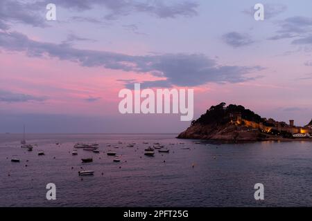 Les belles couleurs d'un coucher de soleil sur Tossa de Mar, Espagne, reflètent les eaux calmes de la mer Banque D'Images