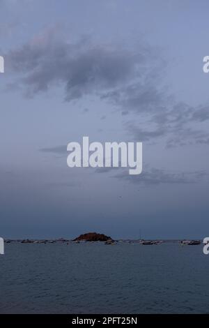 Le soleil se couche sur les sables dorés de Tossa de Mar, en Espagne, et diffuse une lumière chaude sur la plage Banque D'Images