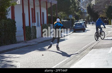 jeune femme en train de roller sur la route un jour ensoleillé Banque D'Images