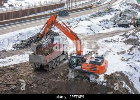 Pelle hydraulique à chenilles Hitachi ZX300LC chargeant un camion dans le district de Pasila à Helsinki, en Finlande Banque D'Images
