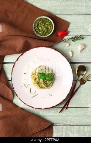 Assiette de pâtes au pesto savoureuses sur fond de bois de couleur Banque D'Images