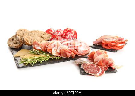 Assiettes en ardoise avec assortiment de viandes de charcuterie savoureuses et pain isolés sur fond blanc Banque D'Images