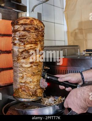 Gyros traditionnels grecs juteux grillés au feu et hachés par un couteau Banque D'Images