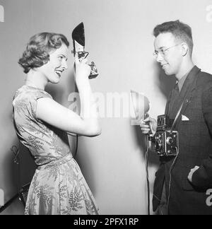 Photographes dans le 1950s. Une jeune femme photographie un autre photographe. Son appareil photo est un Rolleiflex de la société allemande Rollei pour film de 60 mm. Suède 1956. Photo Kristoffersson Réf. BX37-10 Banque D'Images