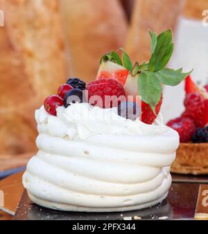 Dessert Pavlova agrémenté de baies d'été, de framboises, de fraises, de bleuets et de cassis. Gros plan du dessert au stand de Prag Banque D'Images