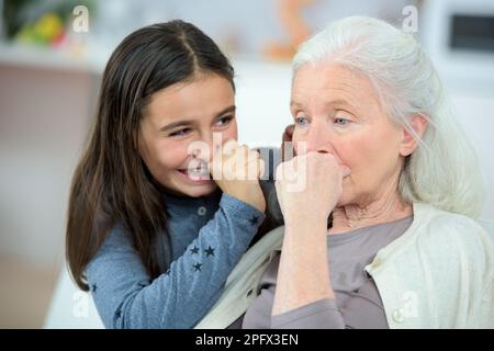 grand-fille riant grand-mère qui a l'air inquiet Banque D'Images