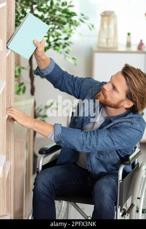 portrait d'un étudiant handicapé en fauteuil roulant choisissant des livres Banque D'Images