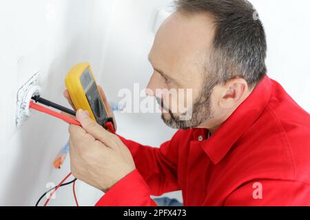 un homme vérifie le circuit électrique en usine Banque D'Images