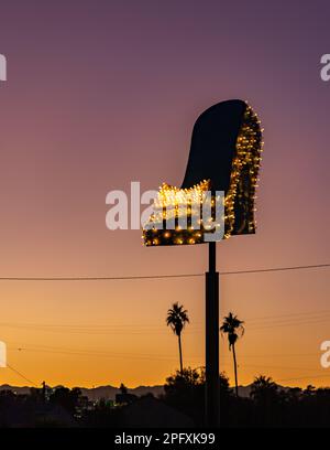 Une photo d'une grande chaussure au néon, qui fait partie du musée Neon de Las Vegas, au coucher du soleil. Banque D'Images