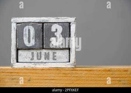 Calendrier pour 03 juin en cubes de bois debout sur une étagère sur fond gris.avec un espace vide pour votre texte.Journée mondiale du vélo Banque D'Images