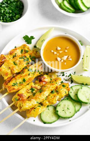 Satay de poulet avec sauce aux arachides. Brochettes de poulet grillées servies avec une sauce trempée aux arachides. Banque D'Images