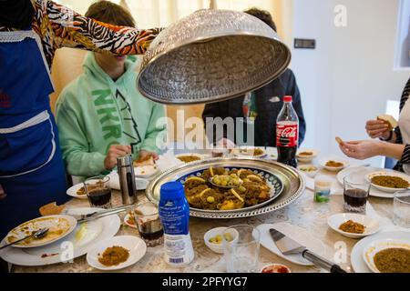 Les touristes américains se préparent à manger pendant qu'une femme présente le repas au Maroc de Fès Banque D'Images