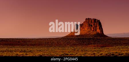 Coucher de soleil coloré dans le désert au-dessus d'une seule roche de butte ou de mesa dans la campagne de l'Arizona Banque D'Images