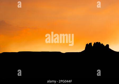 Coucher de soleil coloré dans le désert au-dessus d'une seule roche de butte ou de mesa dans la campagne de l'Arizona Banque D'Images