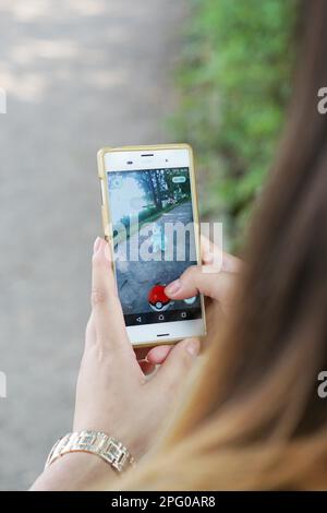 Hanovre, Allemagne - 21 juillet 2016: Une jeune femme jouant à Pokemon va sur son smartphone. L'application de réalité augmentée a été lancée en Allemagne sur 13 juillet Banque D'Images