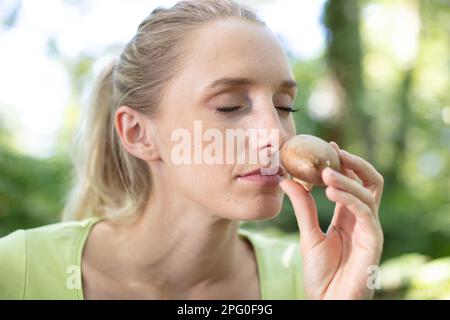 portrait de la jeune femme au foyer qui sent le champignon Banque D'Images