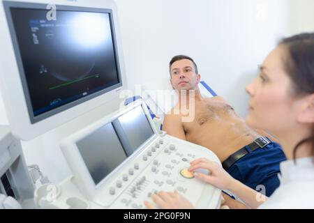 patient mâle subissant une échographie de la glande thyroïde Banque D'Images