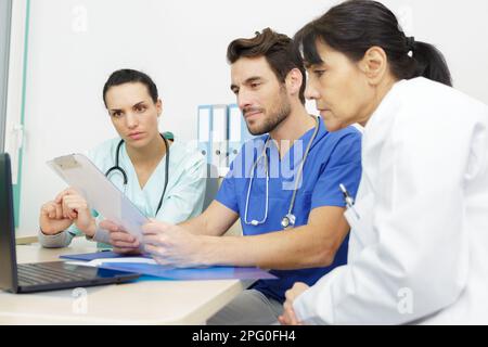 Femme en apprentissage avec une équipe de médecins en clinique Banque D'Images