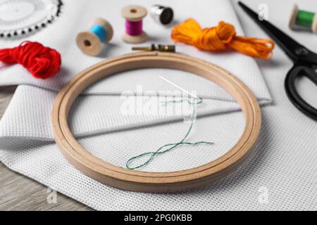 Cerceau à broderie, tissu et autres accessoires sur table en bois Banque D'Images